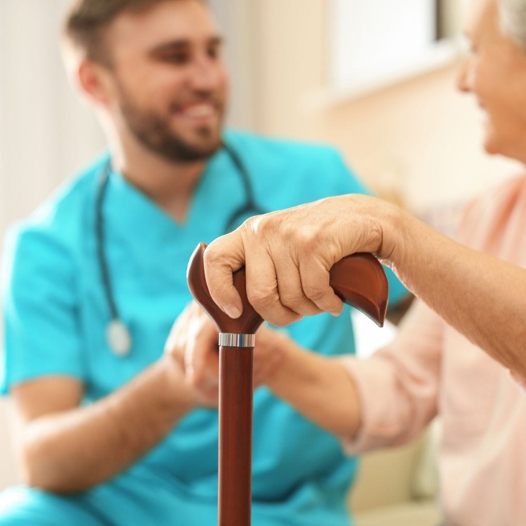 Caring nurse holding elder hand